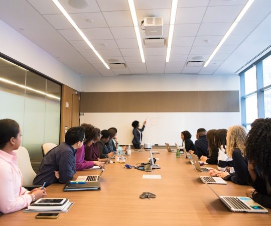people_on_conference_table_looking_at_talking_woman-vs8t6u